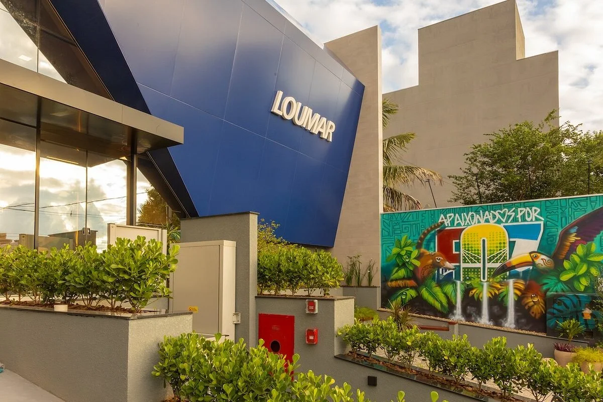 Fachada da Loumar Turismo em Foz do Iguaçu, com a marca Loumar e mural Apaixonados por Foz