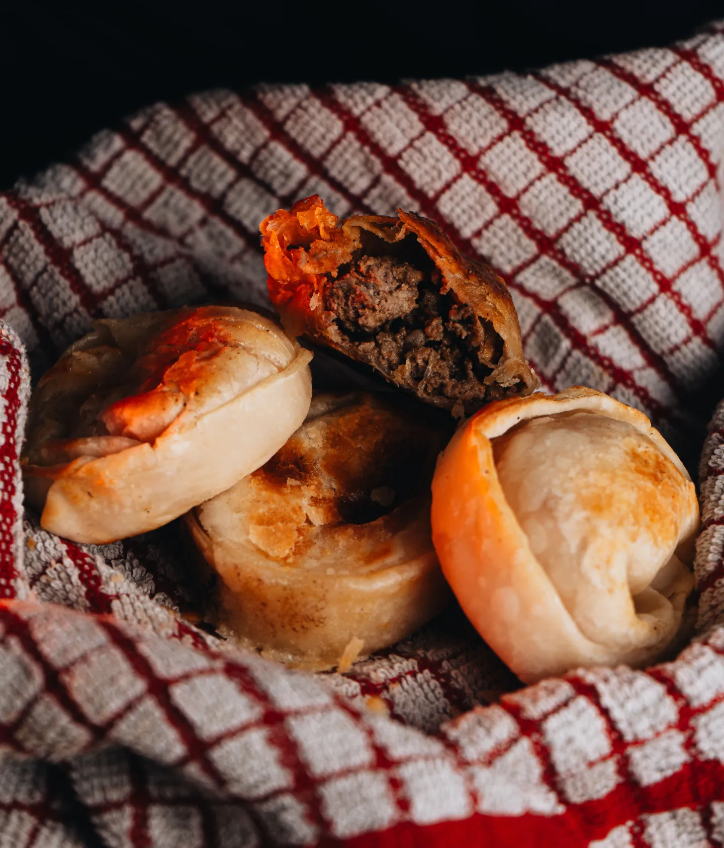 Empanadas argentinas sobre um pano xadrez, em foto ilustrativa